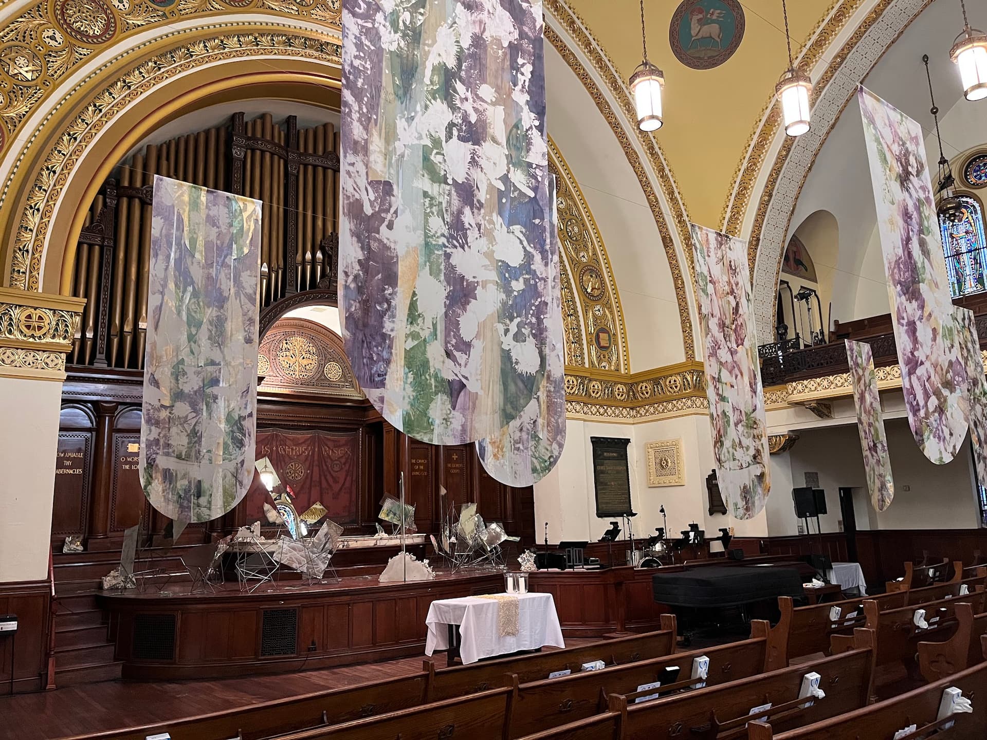 Painted banners hang over pews in a sanctuary.