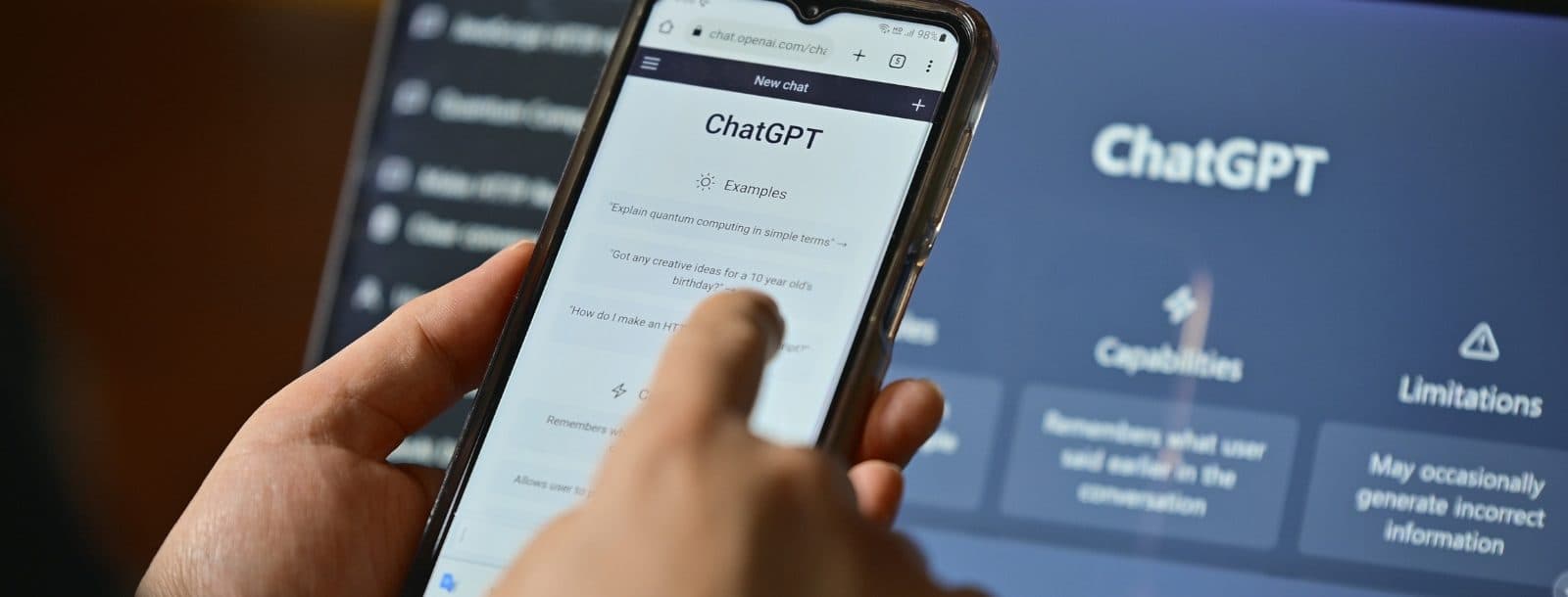 A person uses ChatGPT on their phone. ChatGPT is also open on their laptop.
