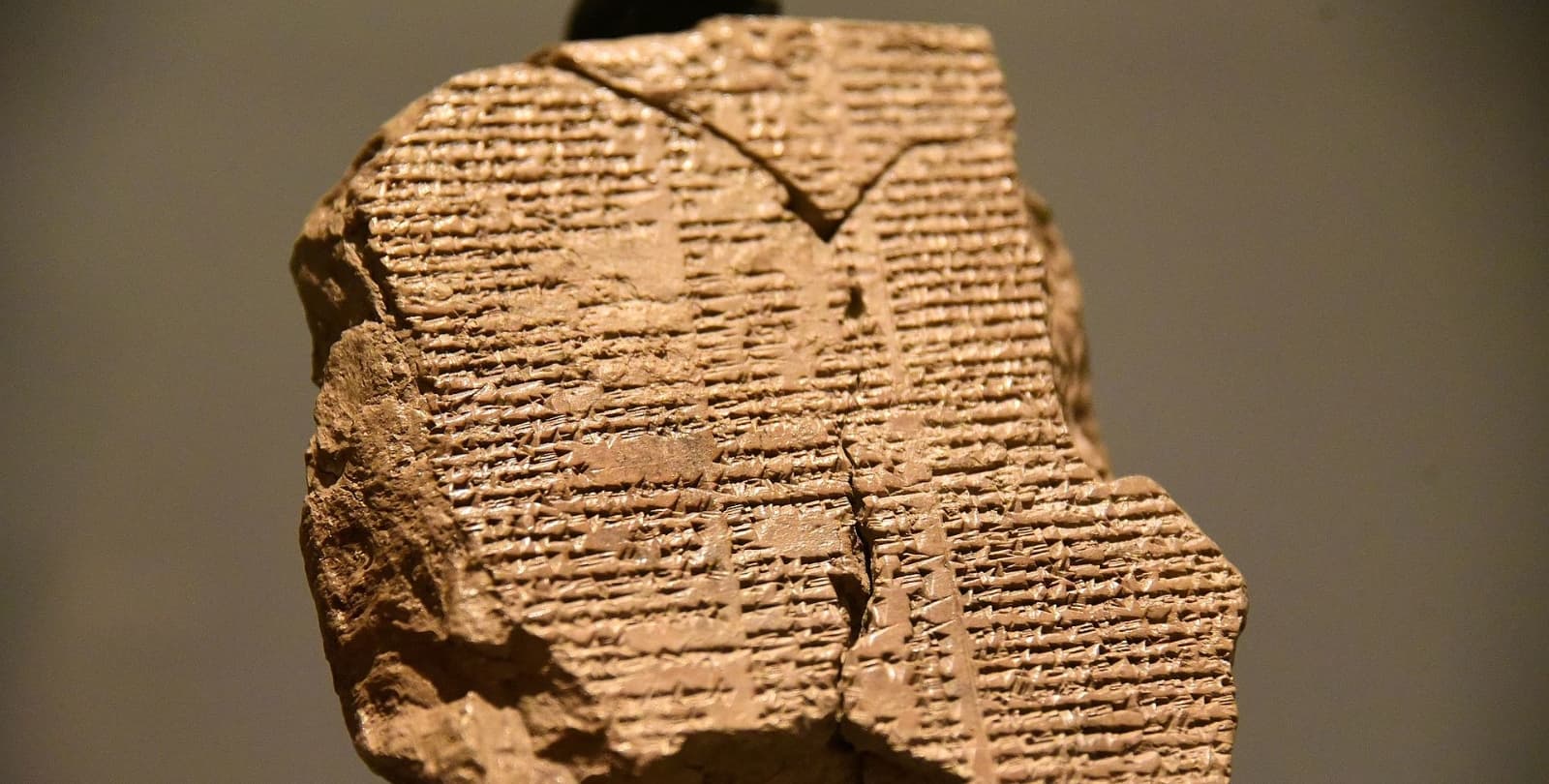 Portion of a tablet mounted in a museum. The tablet is cracked toward the top and bottom.
