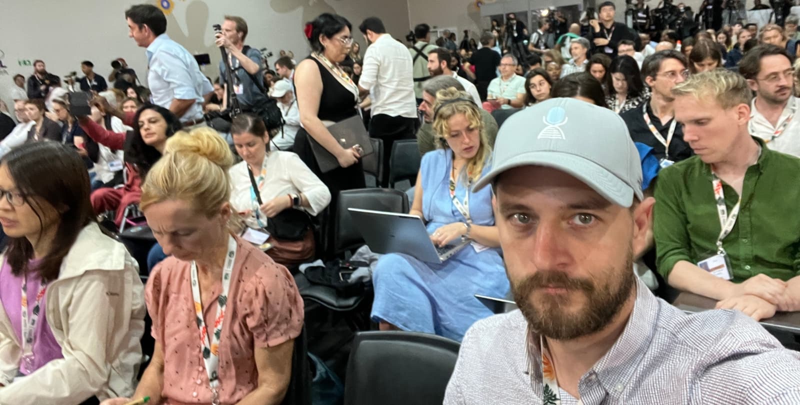 Colin sits among a crowd in a session at COP30.