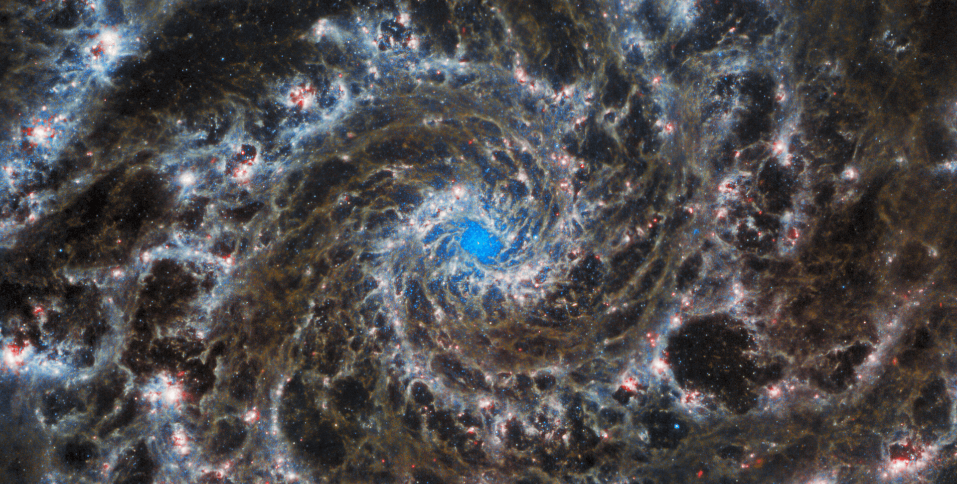 A photo by the James Webb Space Telescope showing a dark spiral surrounding a small, blue patch of space.