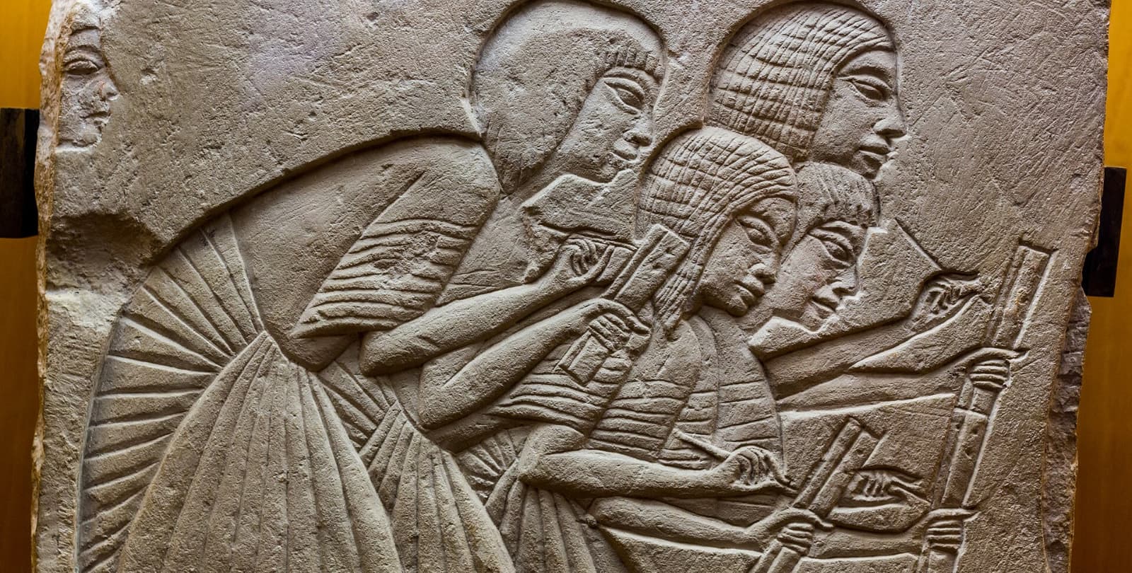 Image carved into stone of four scribes at work.