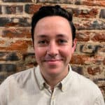 Headshot of Aaron Black. Aaron has black hair and is wearing a button-up shirt.