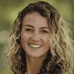 Photo of Laura rake Schulteis. Laura has brown and blond hair and she is smiling.
